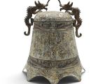 une clochette en métal ornée d'hippocampes sur un fond blanc