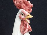 a white rooster with a red comb on it ' s head