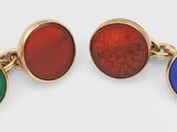 two pairs of cufflinks with red, green, and blue stones