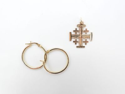 deux bagues en or et une croix sur fond blanc