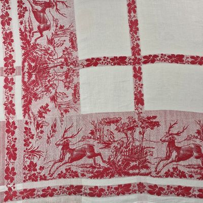 une image représentant une nappe rouge et blanche ornée de cerfs et de fleurs
