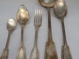 five spoons and a fork sitting on a table
