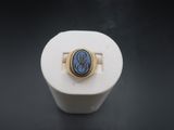 an image of a gold ring with a blue stone in the center