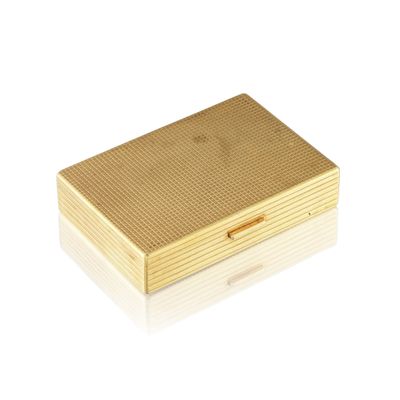 une image représentant un étui à cigarettes doré posé sur une surface blanche