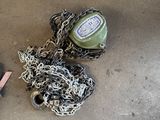 une bouteille et des chaînes par terre, à côté d'une paire de chaussures