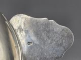 a close up of a silver plate with a flower on it