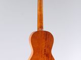 a wooden guitar hanging from a string on a white background