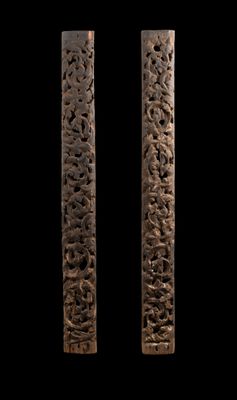 paire de poteaux en bois sculptés, ornés de motifs sur fond noir