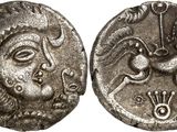 a silver coin with an image of a woman and a dragon on it
