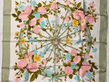 un foulard carré orné de fleurs roses et bleues sur fond vert