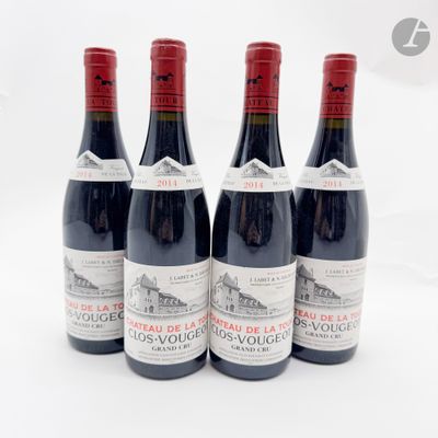quatre bouteilles de vin rouge sont alignées sur une surface blanche