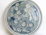 a blue and white plate on a white surface