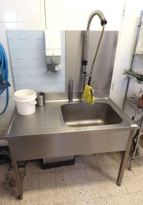 a stainless steel sink with a faucet and a hose