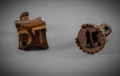 deux morceaux de bois percés d'un trou au milieu et un morceau de bois au milieu