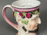 a coffee cup with a man ' s face painted on it