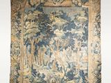 an antique tapestry with a picture of a forest scene on it