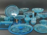a lot of blue glass dishes and plates on the table