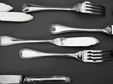 several forks and spoons are arranged in a row on a black surface