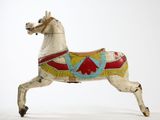 a toy horse that is standing on a white surface