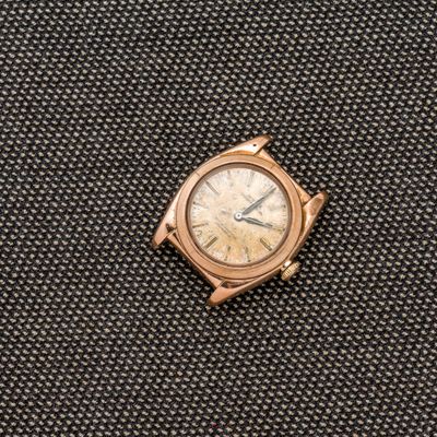 un gros plan d'une montre posée sur un morceau de tissu