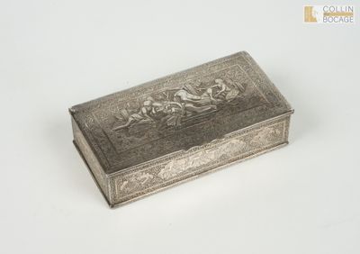 une vieille boîte en argent posée sur une table blanche