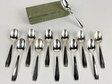 six spoons and six spoons are lined up on a table