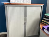 une armoire sur laquelle est posé un calendrier, dans un coin de la pièce