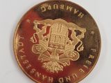 a close up of a gold coin with a building on it