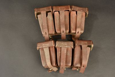 six tan leather magazine pouchs on a gray background
