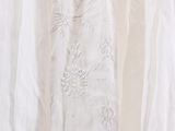 a white dress hanging on a hanger in a room