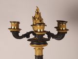 a black and gold candelier with two candles on it