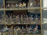 many figurines of soldiers on display in a glass case