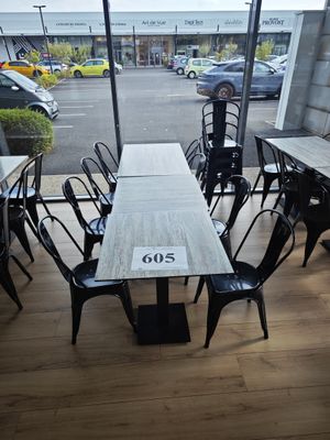 une table et des chaises dans une pièce avec beaucoup de fenêtres