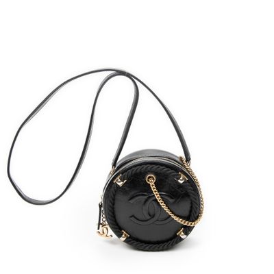 un sac à main noir avec une bandoulière en chaîne et un smiley dessiné dessus