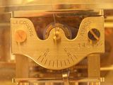 a gold clock that is on display in a glass case