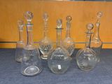 seven glass bottles with different shapes and sizes
