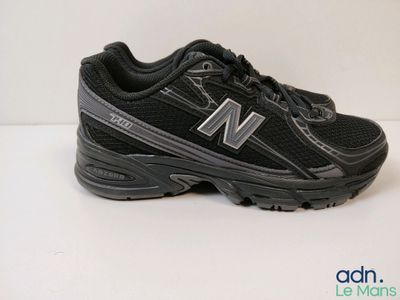 un gros plan sur une paire de chaussures New Balance posées sur une surface blanche