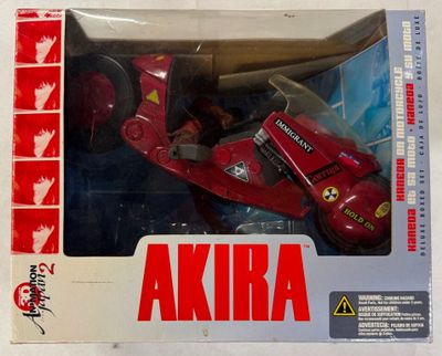 une moto jouet rouge dans une boîte munie d'une poignée noire