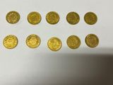 a bunch of gold coins sitting on top of a white table