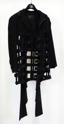 une image représentant un manteau noir sur lequel est posée une cravate