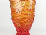 un vase en verre entouré d'une corde rouge
