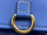 the handle of a blue purse with a gold ring on it