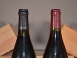 two bottles of wine sitting on a table next to each other