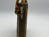 a small metal bottle with a wooden handle on a white surface