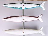 three fish hanging from a metal pole on a white wall