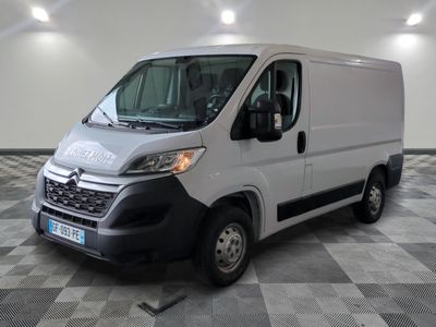 la camionnette blanche est garée dans une grande pièce au sol en damier