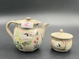 a small tea pot and a small tea pot on a table