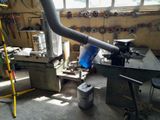 an image of a machine shop with a large pipe sticking out of it ' s side