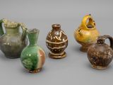 Plusieurs vases sont alignés sur une surface grise