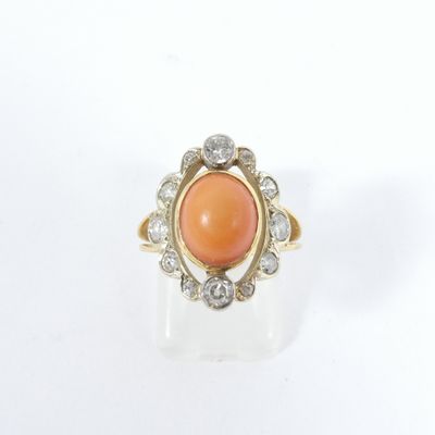un gros plan d'une bague ornée d'une pierre orange entourée de diamants